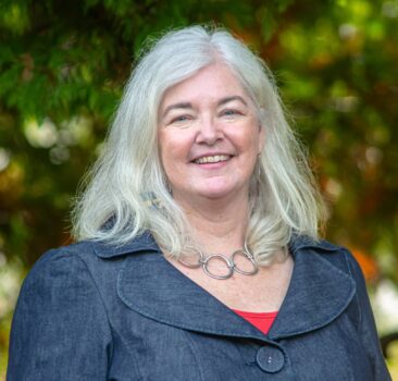 a woman is smiling at the camera