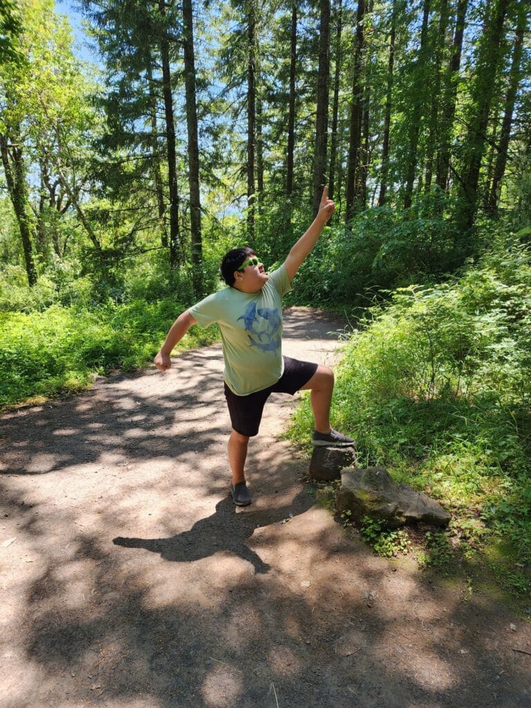 a boy on a hiking trail in the woods