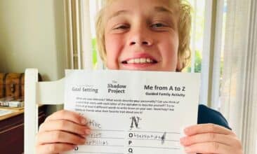 a child holding a summer goal setting worksheet