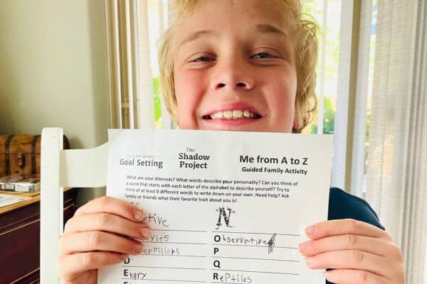 a child holding a summer goal setting worksheet