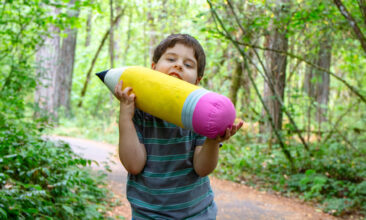 a child with a large pencil