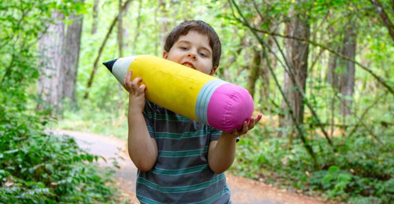 a child with a large pencil